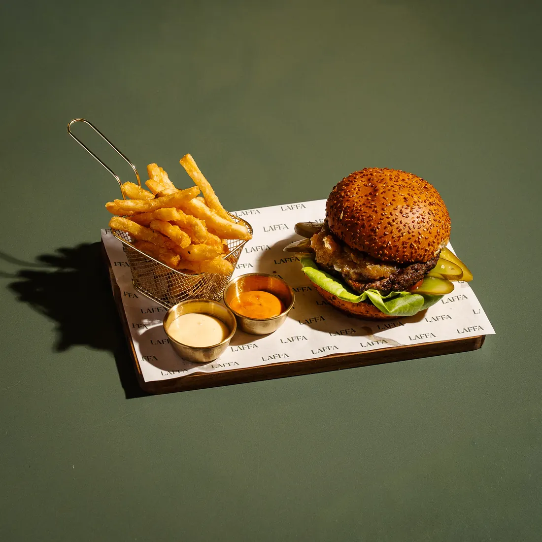 Wagyu burger with fries and dips on branded Laffa & Co paper