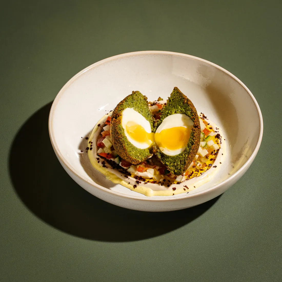 Scotch egg falafel — soft egg wrapped in herbed falafel over chopped salad