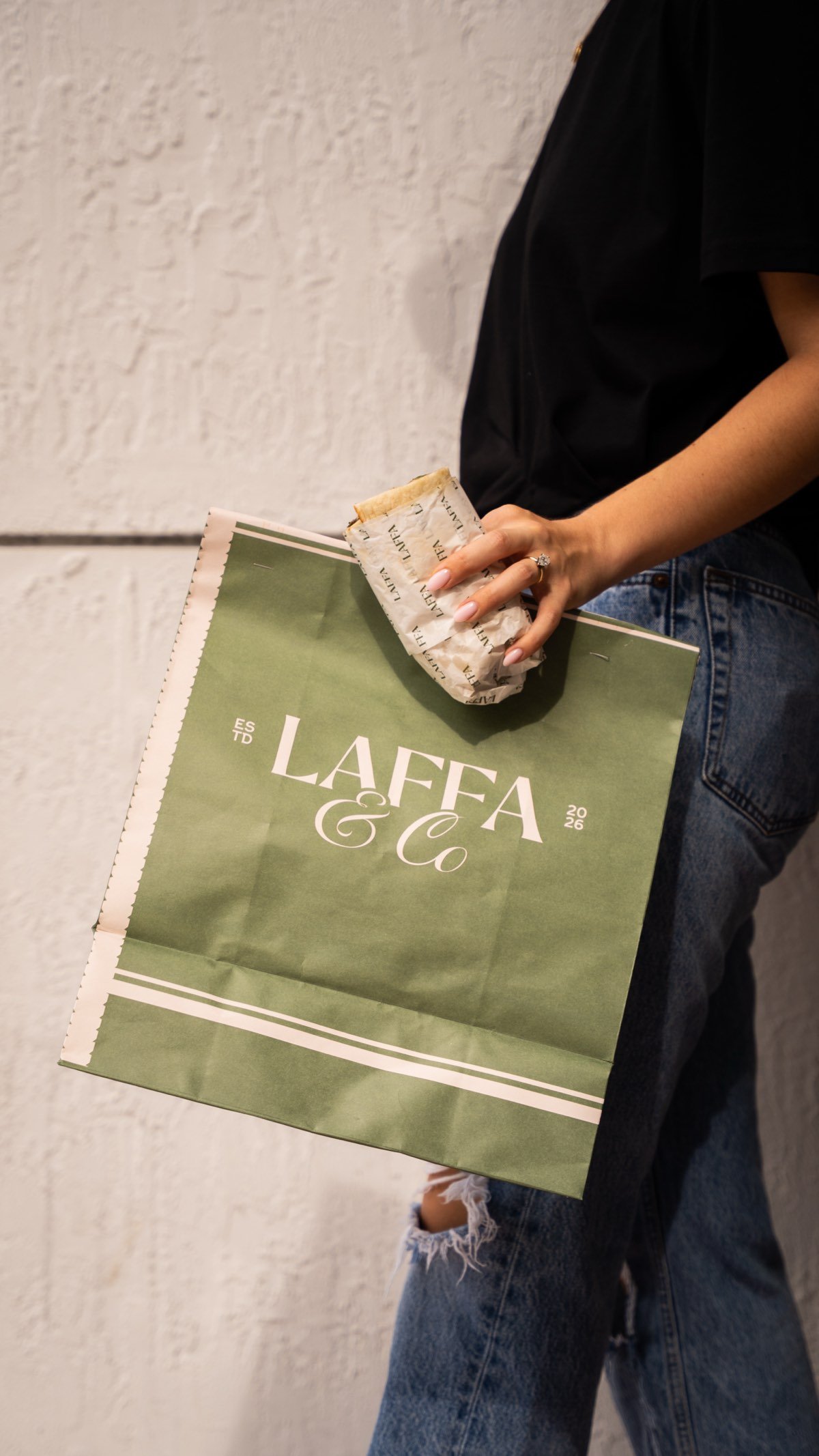 Laffa & Co branded takeout bag with a wrapped sandwich